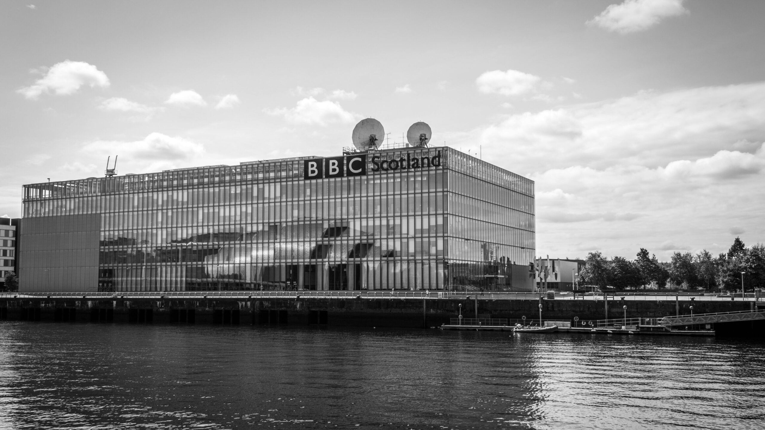 Black and white photo of BBC Scotland's modern building by the river.