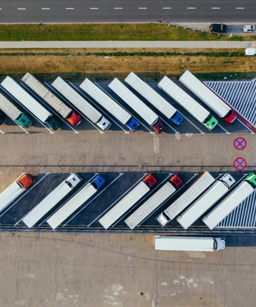 Overhead shot of semi-trucks parked in Poznań, Poland, demonstrating transportation logistics.