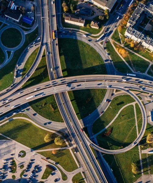 Aerial shot of a complex highway intersection in a vibrant urban cityscape.